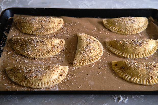 Apple cinnamon hand pies on a parchment-lined baking sheet