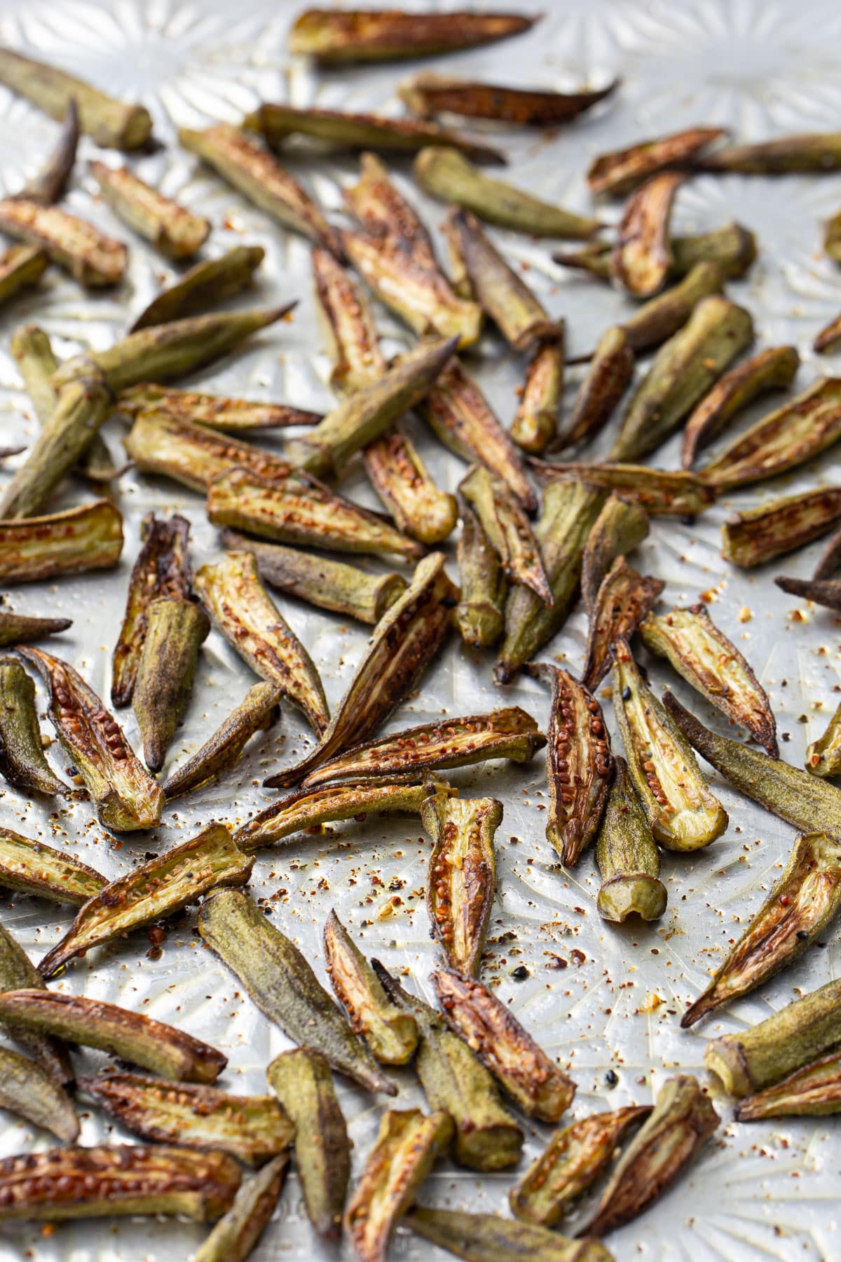 Aluminum sheet pan with Crispy Oven-Roasted Okra, golden brown just out of the oven.
