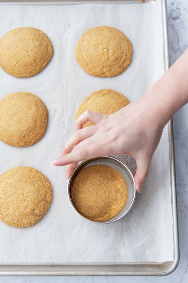 After baking, swirling a round cookie cutter around the still-warm cookies to perfect the shapes.