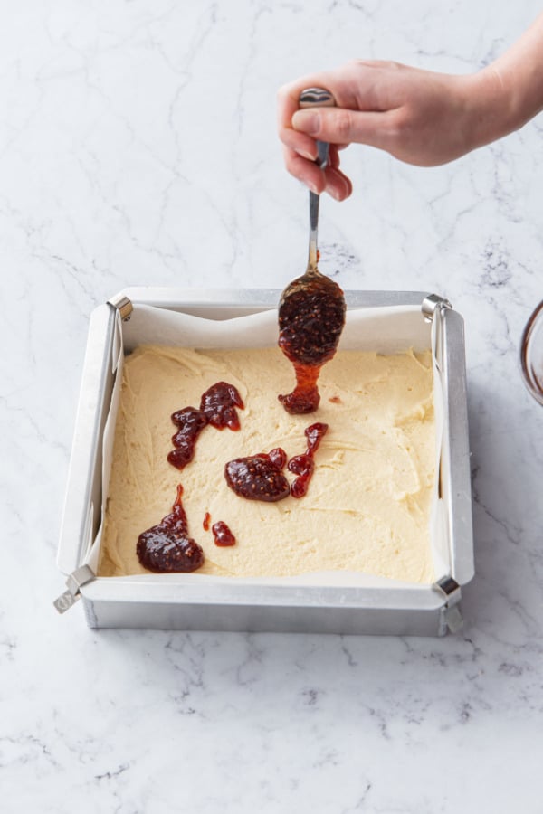 Dropping dollops of fruit jam on top of cake batter.