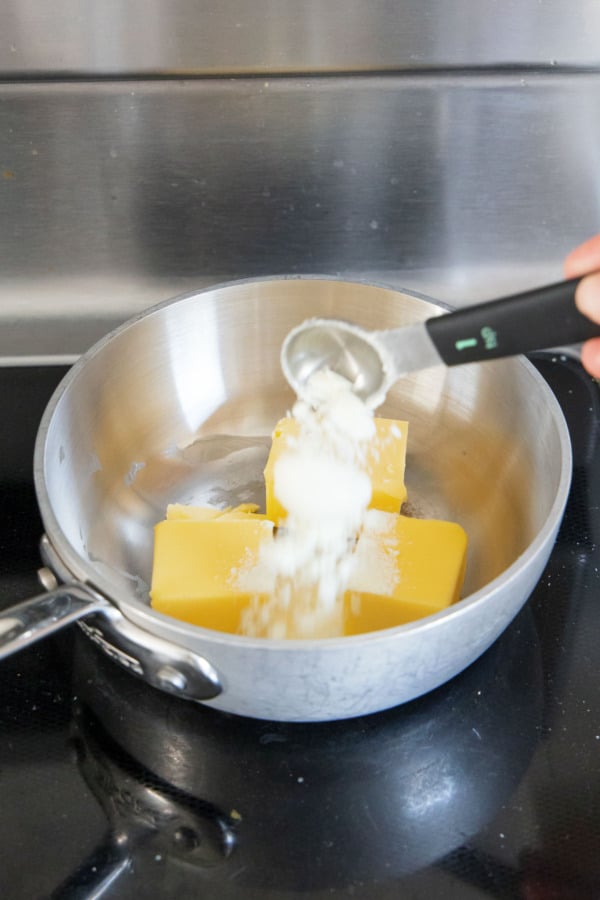 Adding dry milk powder to butter in a small saucepan before browning.