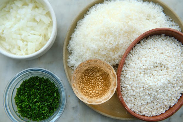 ingredients for making risotto including rice, onion, wine