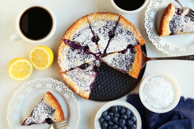Lemon blueberry gooey butter cake sliced and served with black coffee.