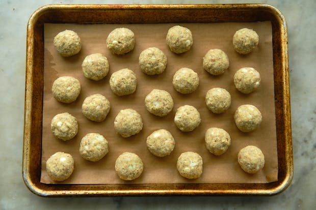 Tempeh ponzu balls arranged on a parchment-lined baking sheet prior to cooking