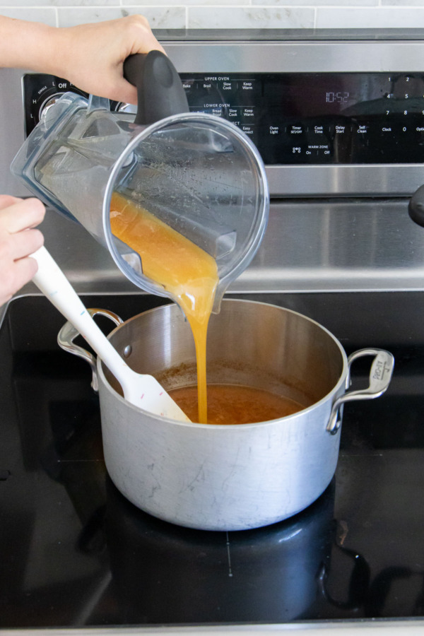 Pouring blended cider-pectin mixture back into saucepan with remaining cider.